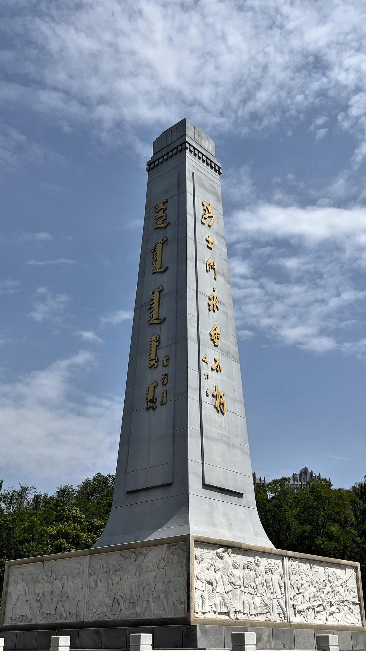 呼和浩特市青城公园内两种文字的人民英雄纪念碑，直冲云霄，矗立在公园中央，巍然屹立