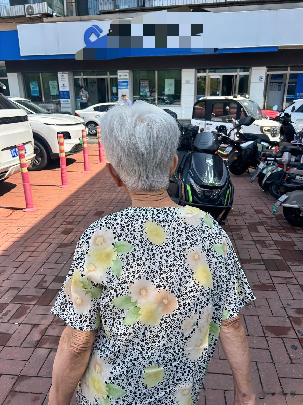目测这个奶奶至少70多岁了！奶奶头发已经全白了！弯腰驼背，穿着一件半袖花上衣！因