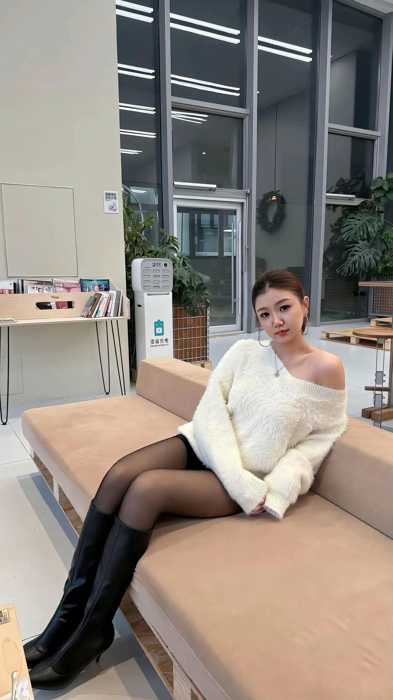 白色毛绒露肩毛衣的温柔，撞上黑丝与长靴的酷飒，柔与刚的碰撞在休闲的室内场景里，揉