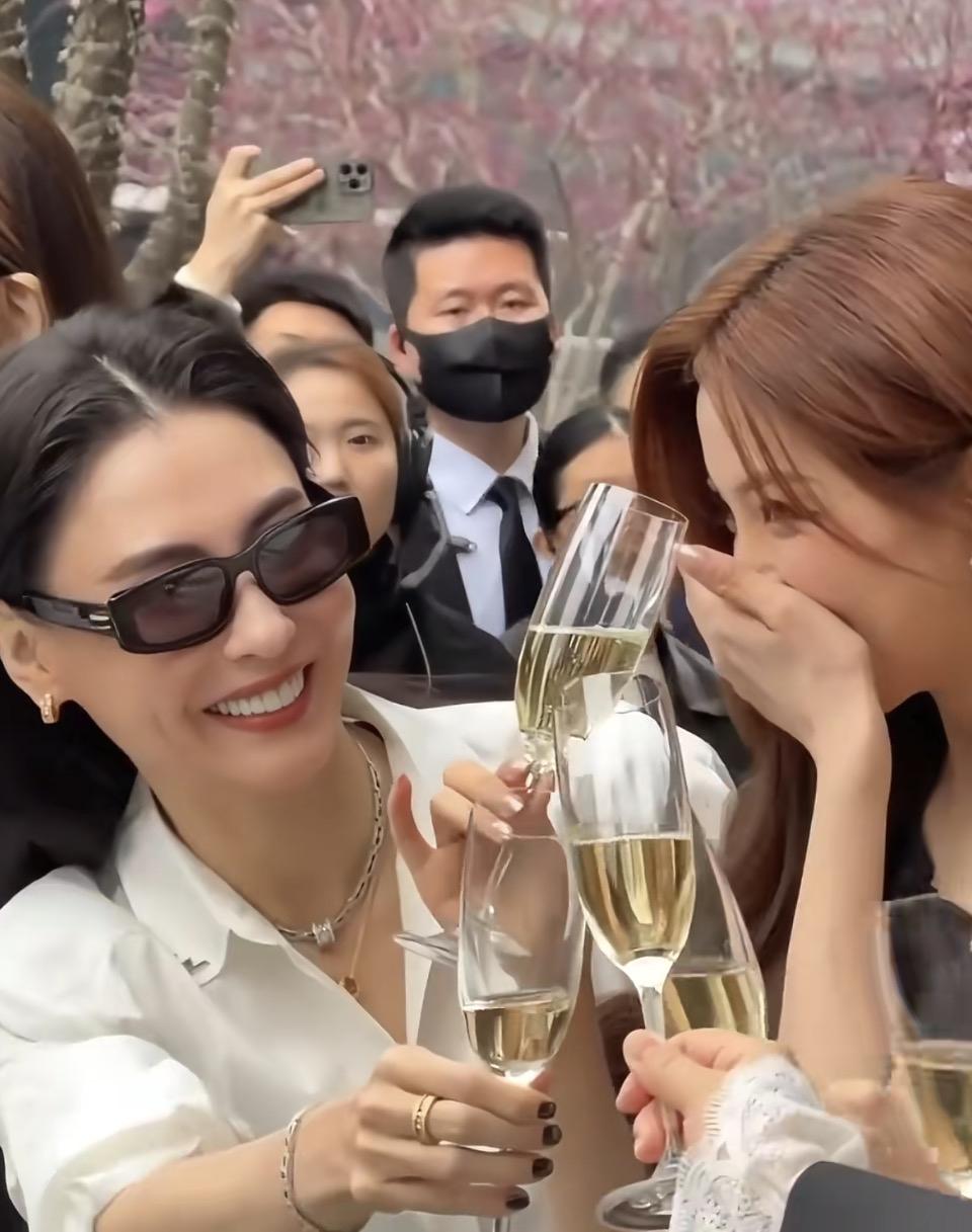 春日花影里，香槟杯轻碰出细碎的光✨
白衬衫与黑裙的碰撞，是岁月沉淀的从容，也是新