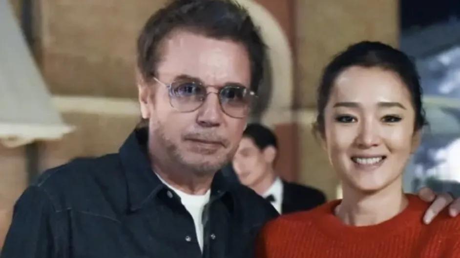 巩俐与丈夫罕见同框，两人恩爱尽显，她以一袭大红色套装惊艳亮相，瞬间成为全场焦点。
