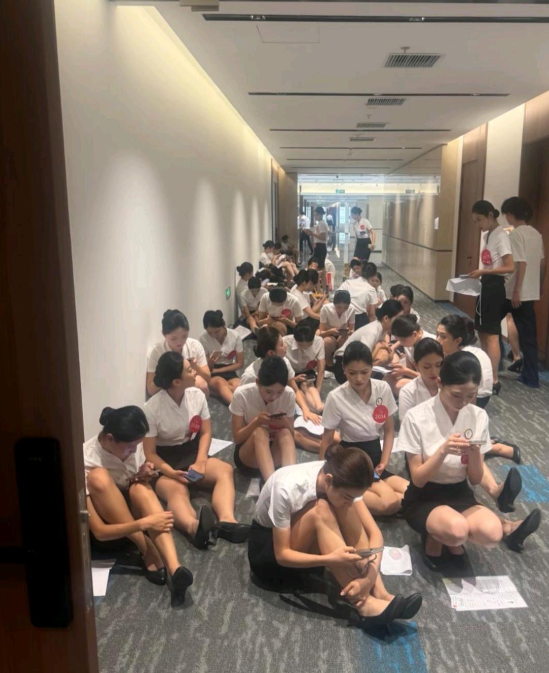 等待面试的空姐们，招聘单位也不准备一些凳子，就这么席地而坐！[尬笑]