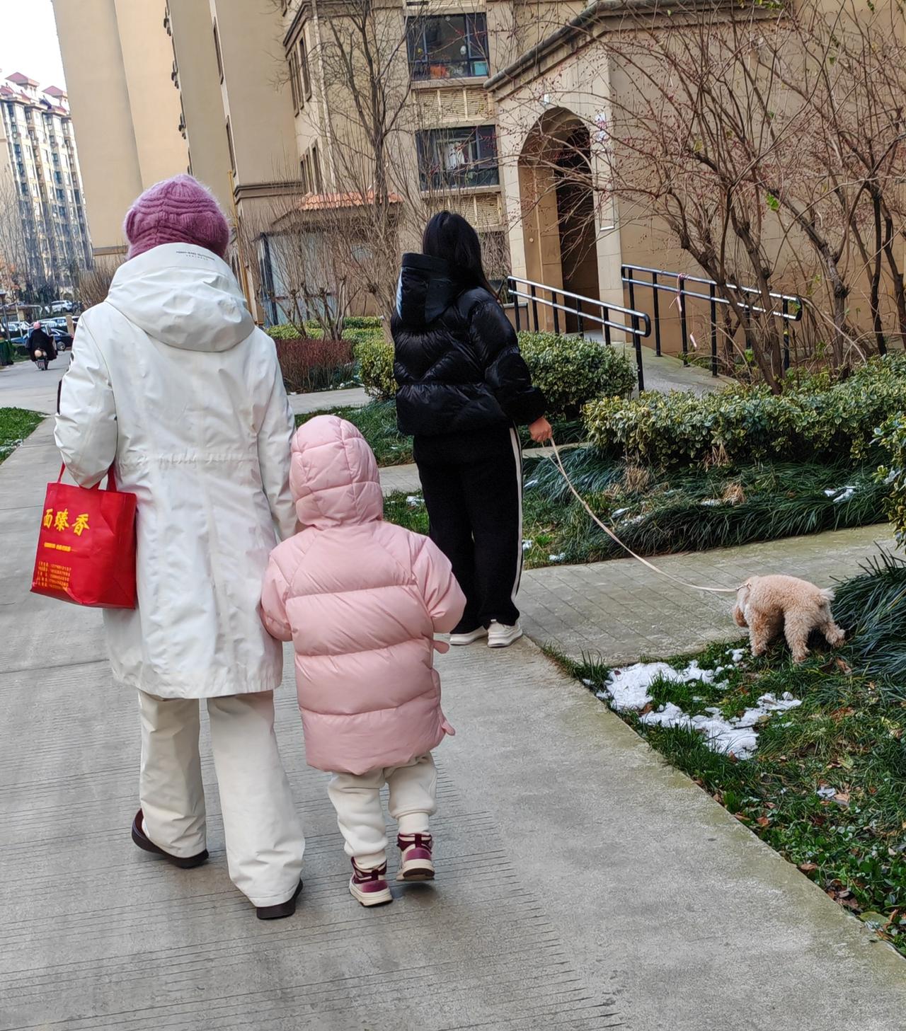 两个女人谁幸福快乐？
        一个女子领着孩子，穿着鲜艳保暖，这是去幼儿