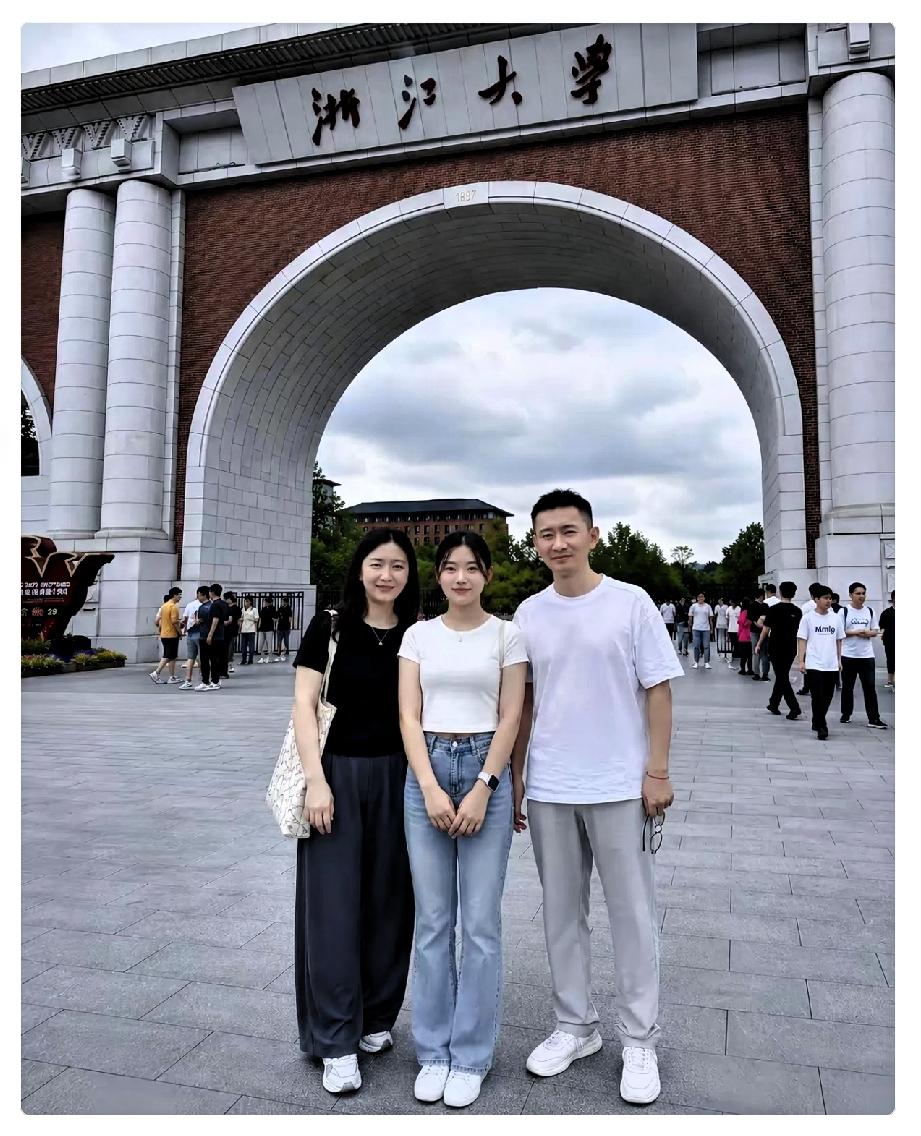 父母送女儿上大学，
在校园门口的合影。

送孩子去大学报到，校门口那张合影，真成
