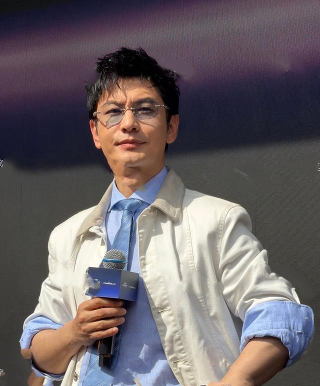 出席活动的黄晓明太帅了！乌黑浓密的秀发，鼻梁上架着金边眼镜，蓝色衬衫搭配深蓝色条