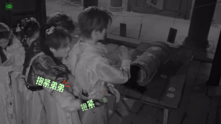 看仨人黑暗里肩背相贴、手臂依次收紧——张凌赫护丁程鑫，丁程鑫护周柯宇，周柯宇大概