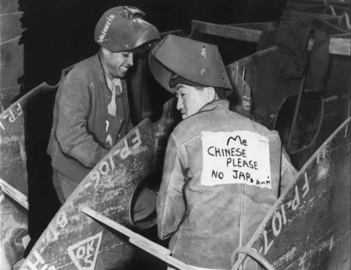 珍珠港事件过去十个月，加州一处工地上，一个扛着麻袋的华裔工人背贴手写纸条——“我