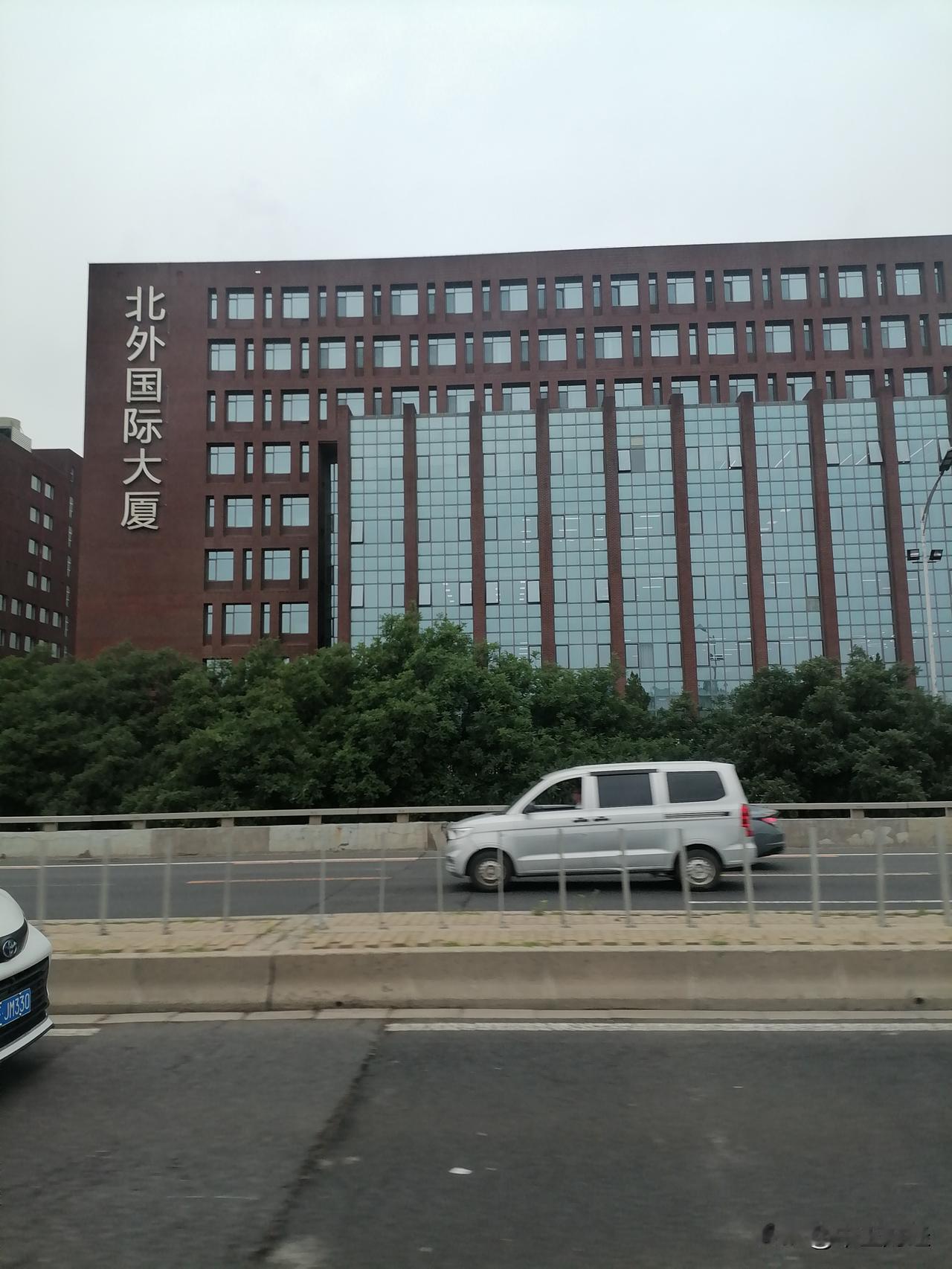 这里是北京，乘公交至清华大学的路上。有人知道那千上升旗形楼是哪个单位吗？