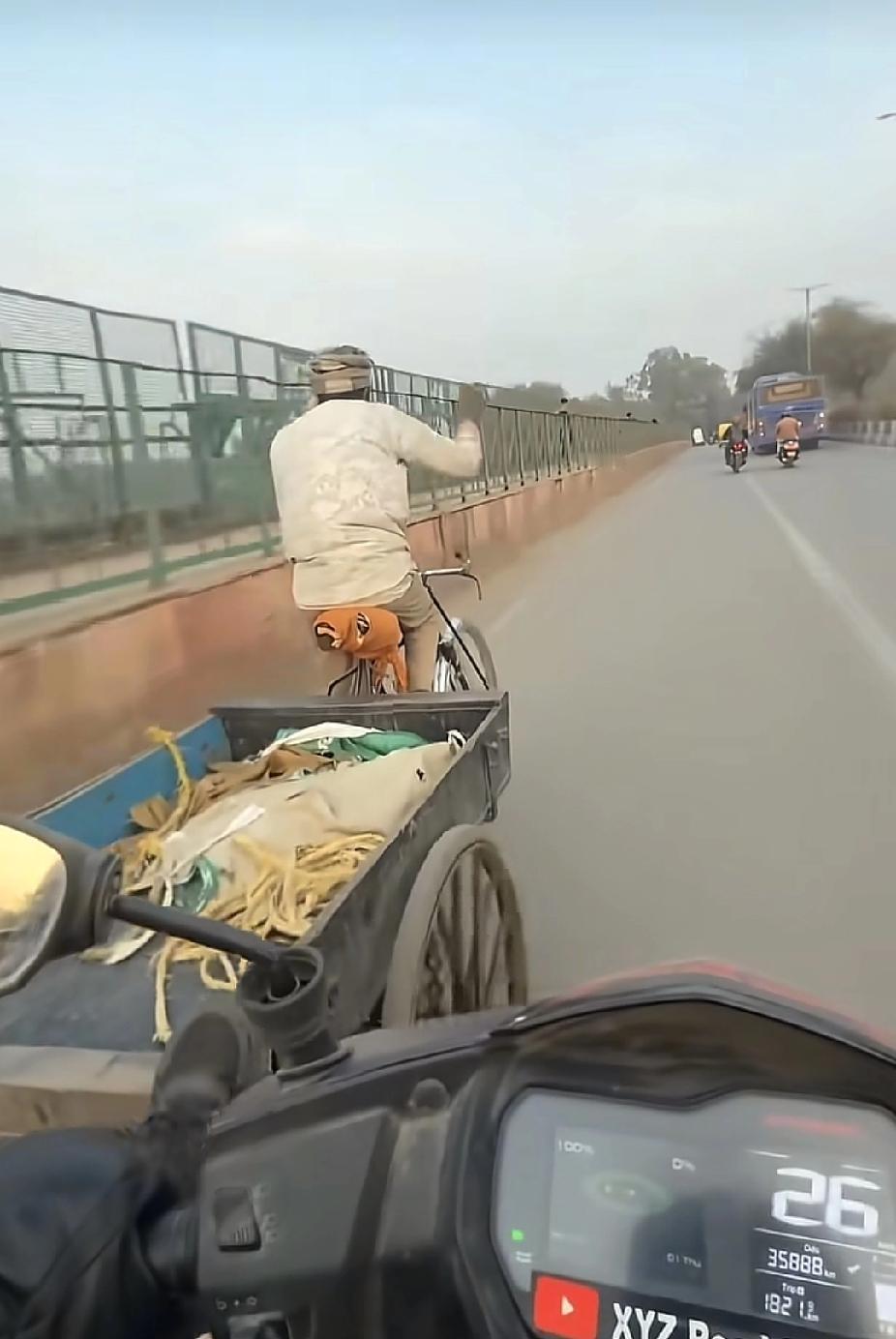 一位老人弯着腰身费劲地推着人力三轮车，走在坡路上，接下来看到的一幕，让路人直呼感