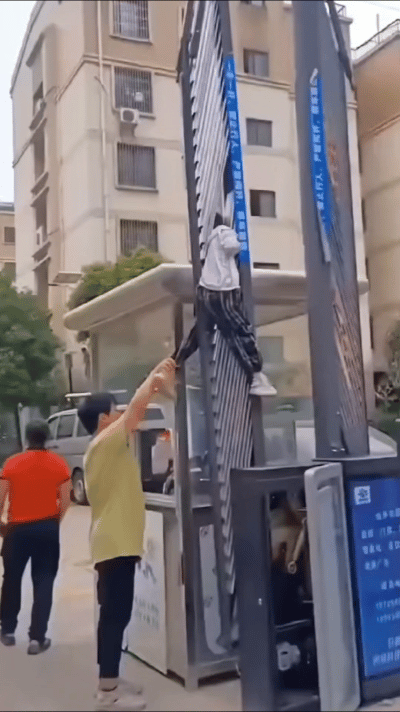 孩子已经骑到栏杆上了，奶奶的情绪也挺稳定，不拉杆子、不托孩子，而是拉孩子的腿。提