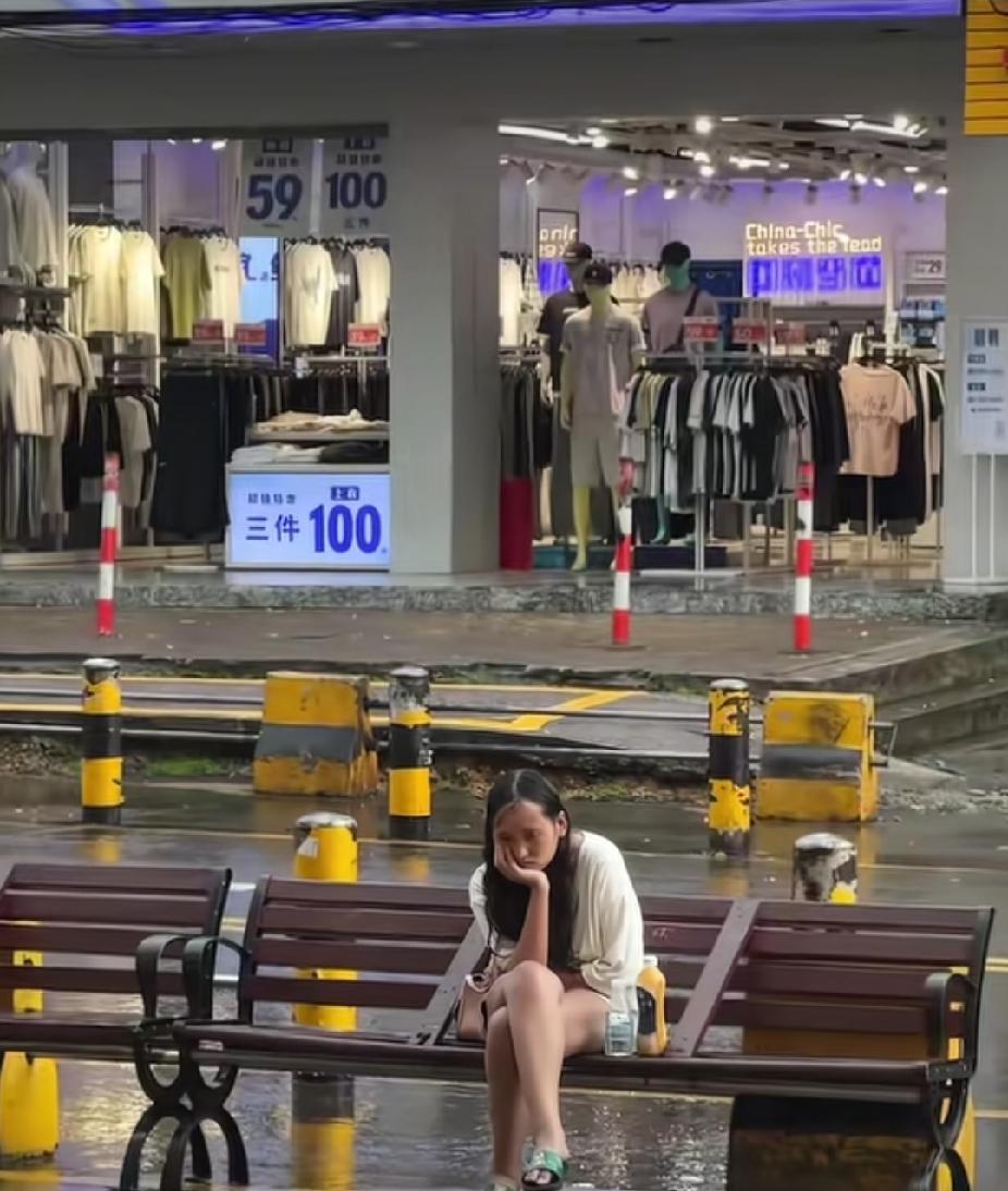 大雨滂沱中，一名女子淋在雨中的样子，让经过的路人瞬间心疼了。

福建的一条街边，