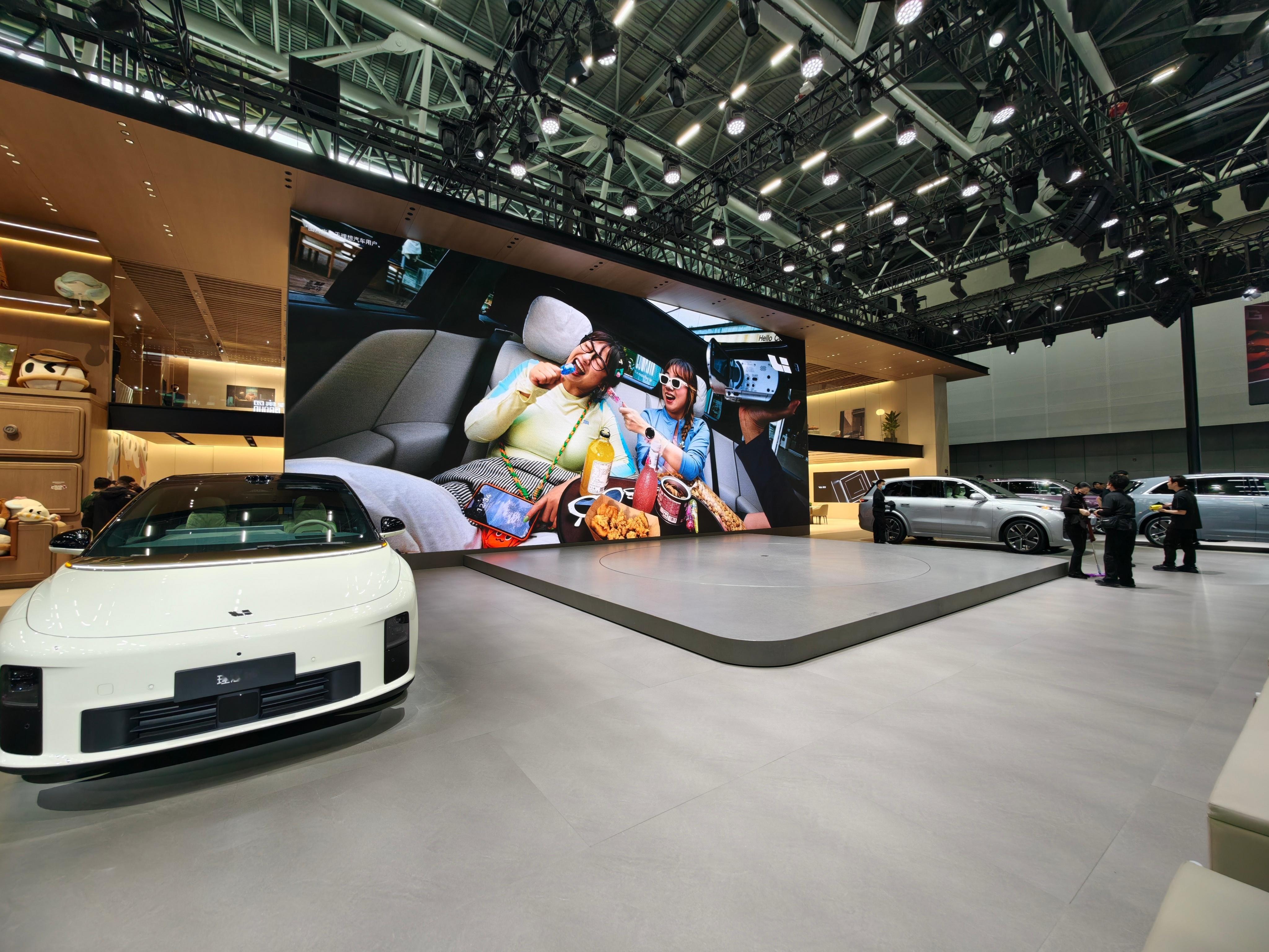 理想今年的展台布置全系车型悉数登场，左边纯电/右边增程再也不用像以前一台车放 N