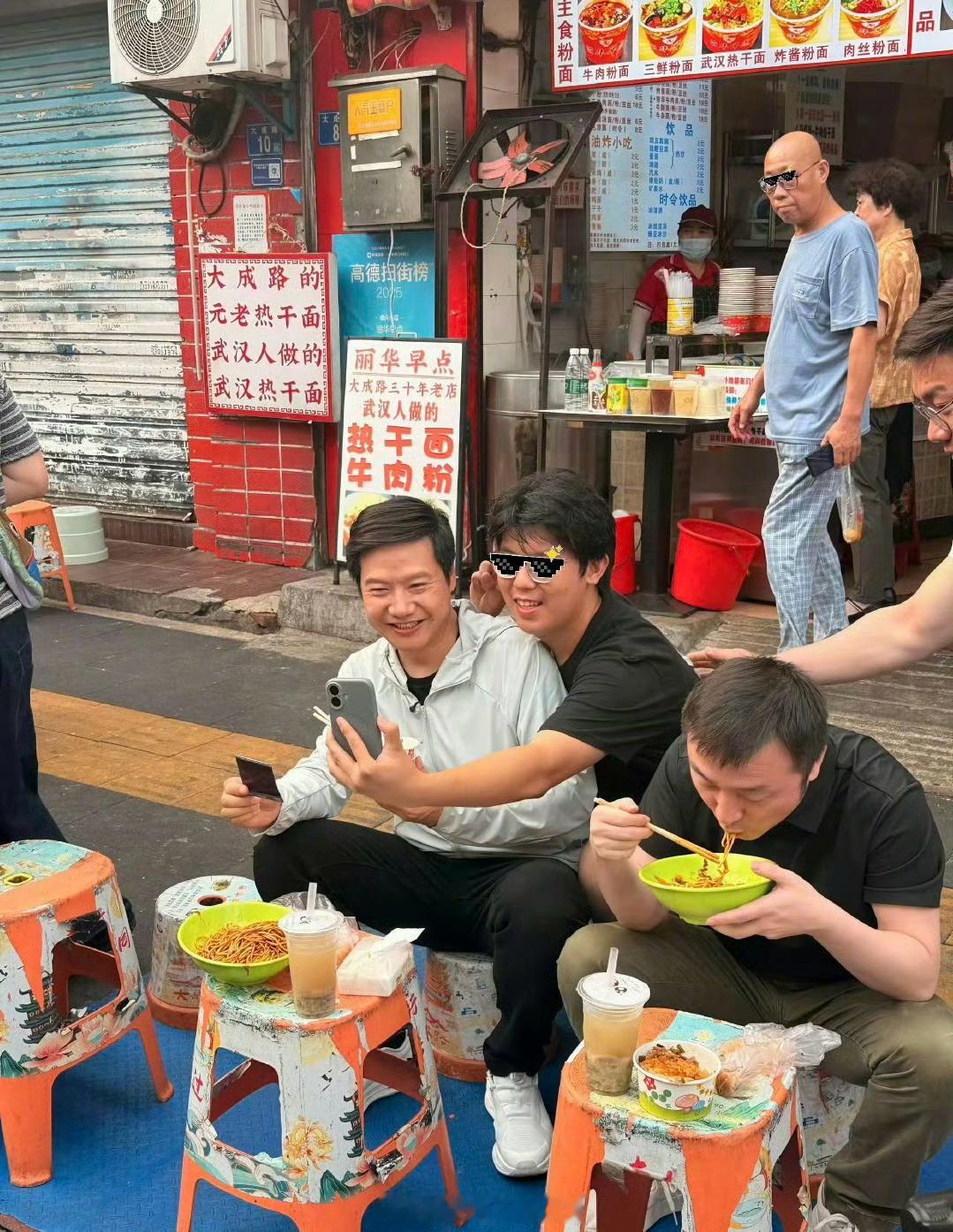 雷军现身武汉过早，和路人合影聊天。网友：谁来了都要坐小板凳 雷军在武汉过早
