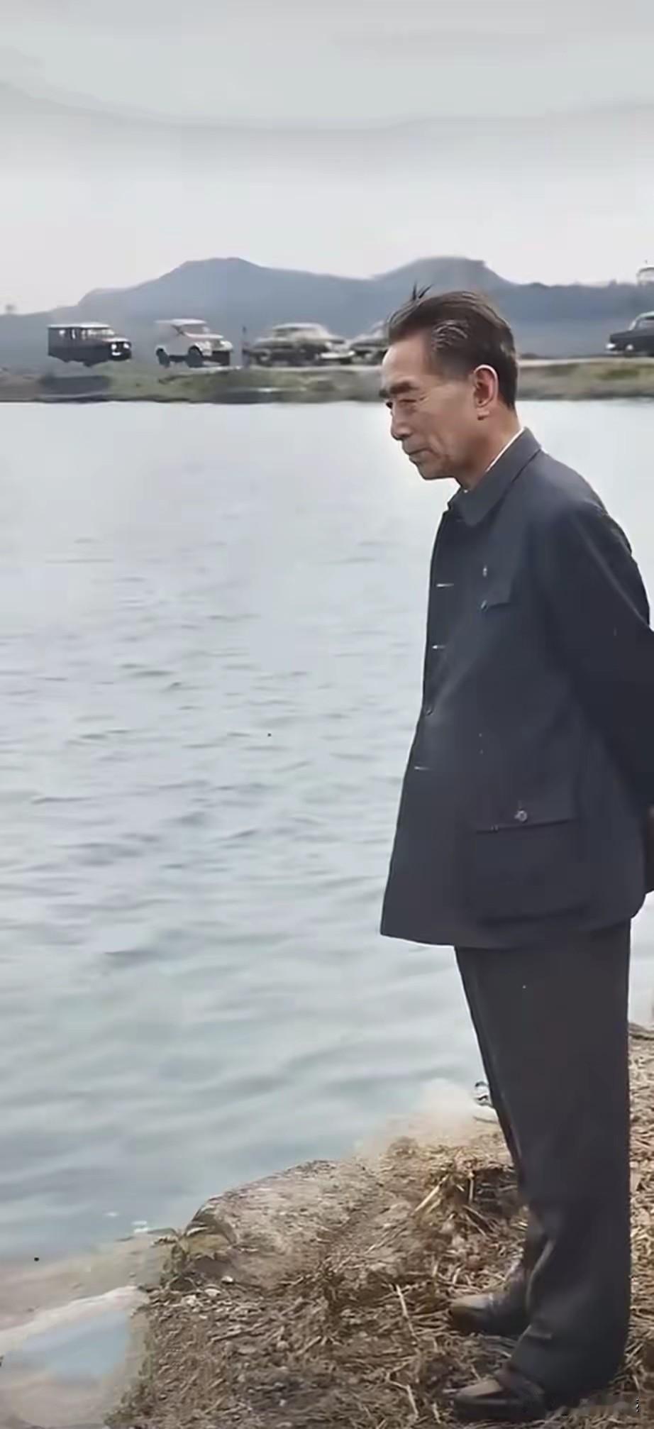 周总理这张照片，神情看起来特别的庄重，特别的严肃，他站在水边，眼睛望着水面，似乎