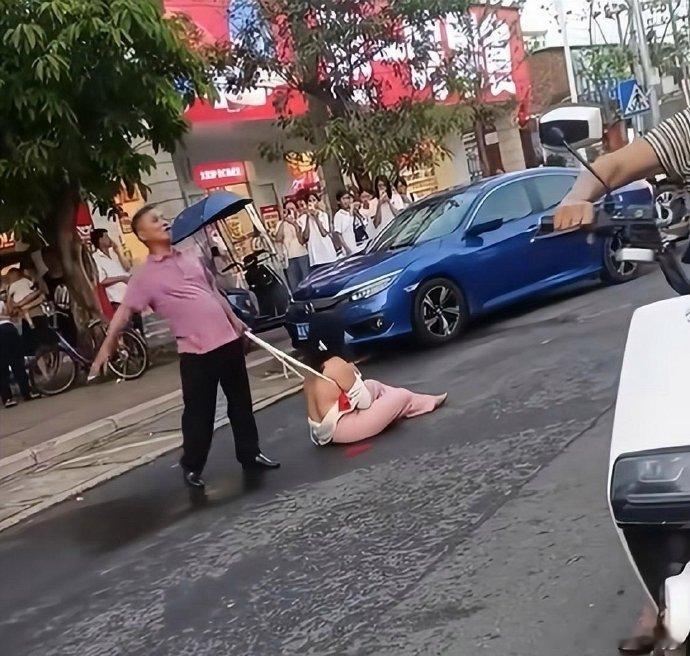 女子出轨后遭游街示众，瘫坐地上衣衫不整，紧抱衣物护尊严。私事被放大，羞辱非解决之