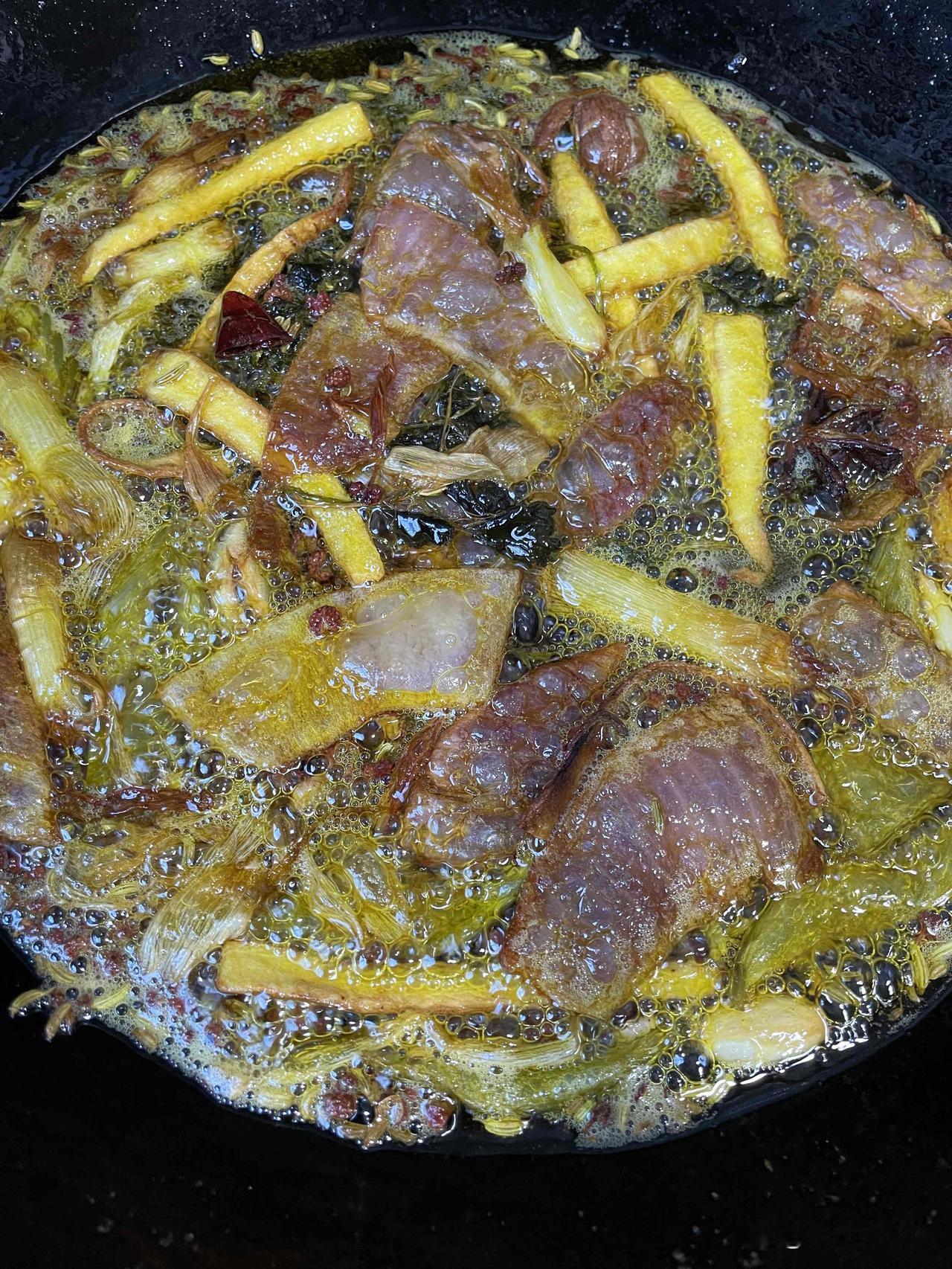 料油色泽渐变，花椒粉、孜然粉、十三香、熟芝麻、秦椒面、细辣面被烧热的料油一泼到底