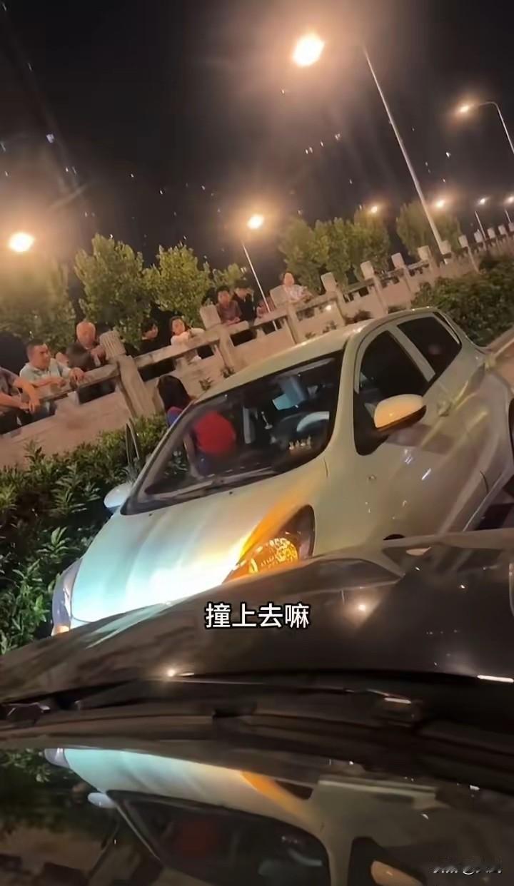女司机路口逆行堵路骂路人，路口一辆白色轿车逆行把车道堵了。正常行驶的车主下车找她