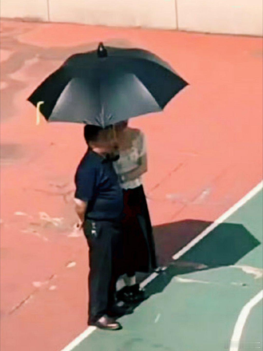 女教师给父亲打伞为何被造谣 操场学生晒太阳活动，女教师给身旁男士撑伞被骂“讨好校