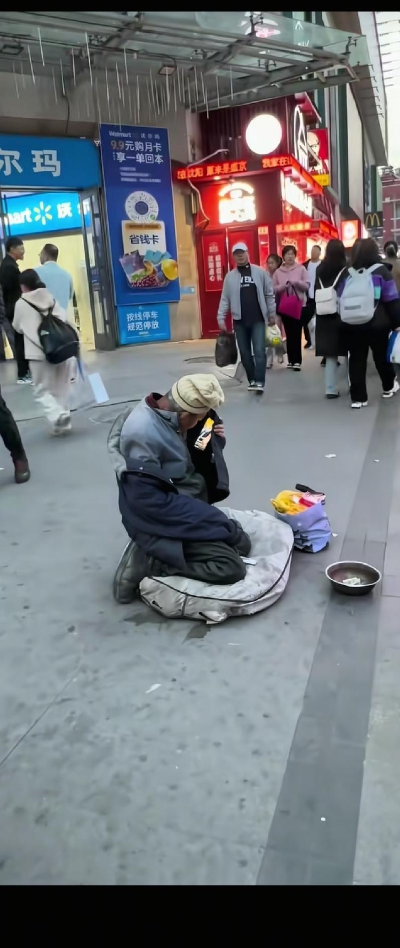 路过的人偶然发现路中间跪着的乞讨大爷业余生活还挺丰富的，空闲时候就在衣服里藏着手