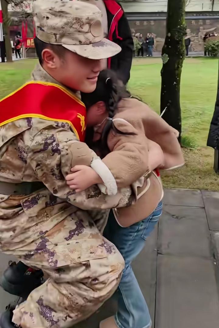 哥哥身穿军装、胸戴大红花，马上就要奔赴军营，妹妹不舍扑进哥哥怀里，强忍着不哭出声