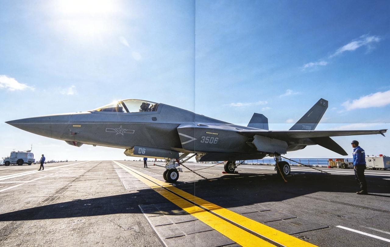 此前未公开过的杂志画报图，歼-35舰载战斗机通过连接到系留点和轮挡的链条固定。