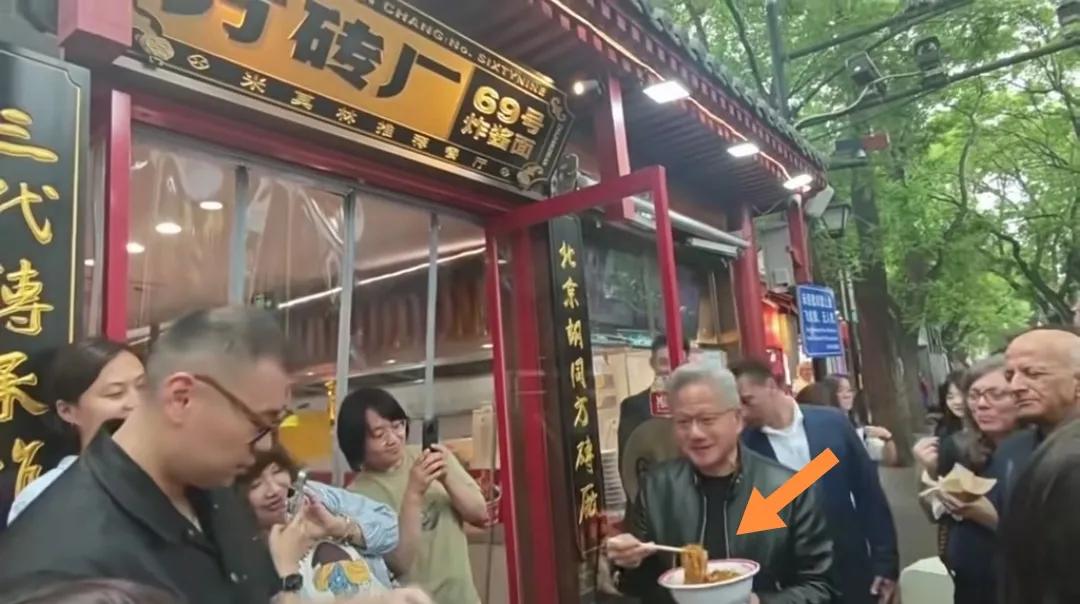 黄仁勋站着手端大瓷碗吃北京炸酱面。