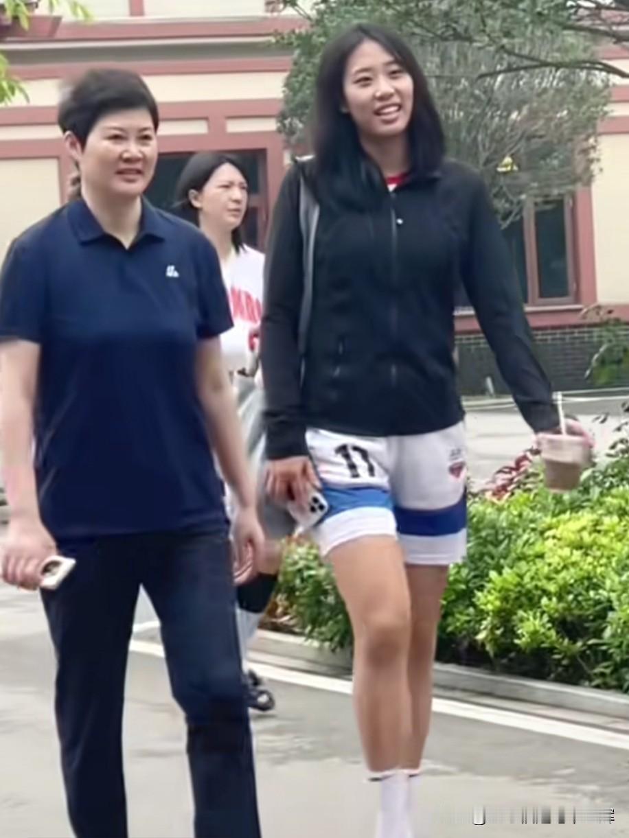 唐子婷身旁，是她的大学恩师李笋南，北师大女篮主教练。
两人并肩同行、轻声交谈，眉