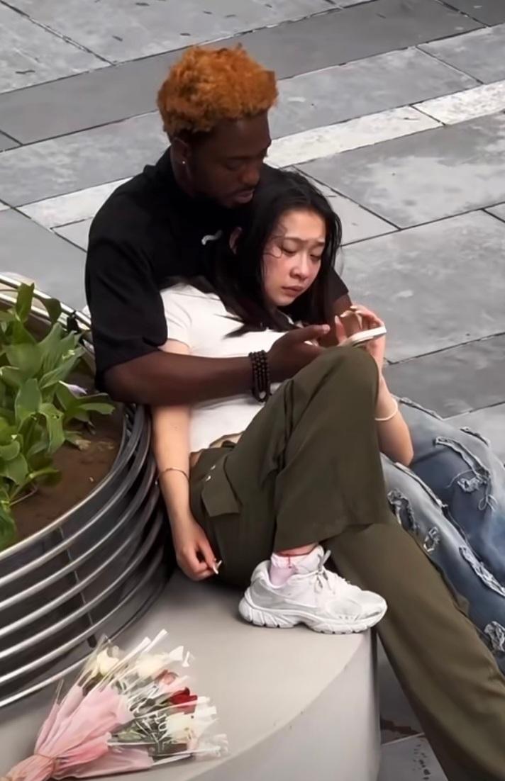 黑人在检查女朋友的手机，看样子，女生很爱这个黑人男朋友