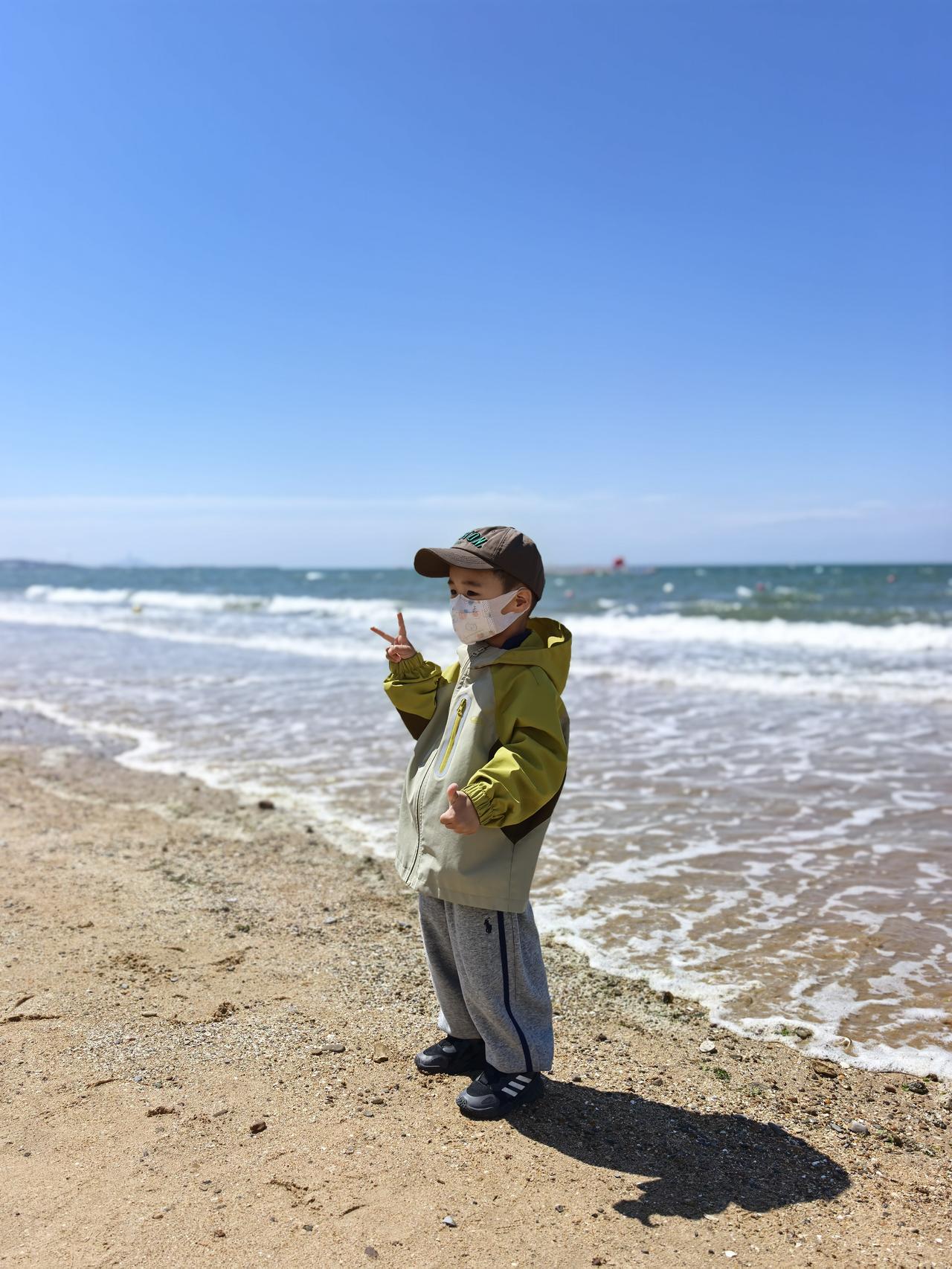 这个小娃娃不相信地球有引力，他在海边反复蹦跳