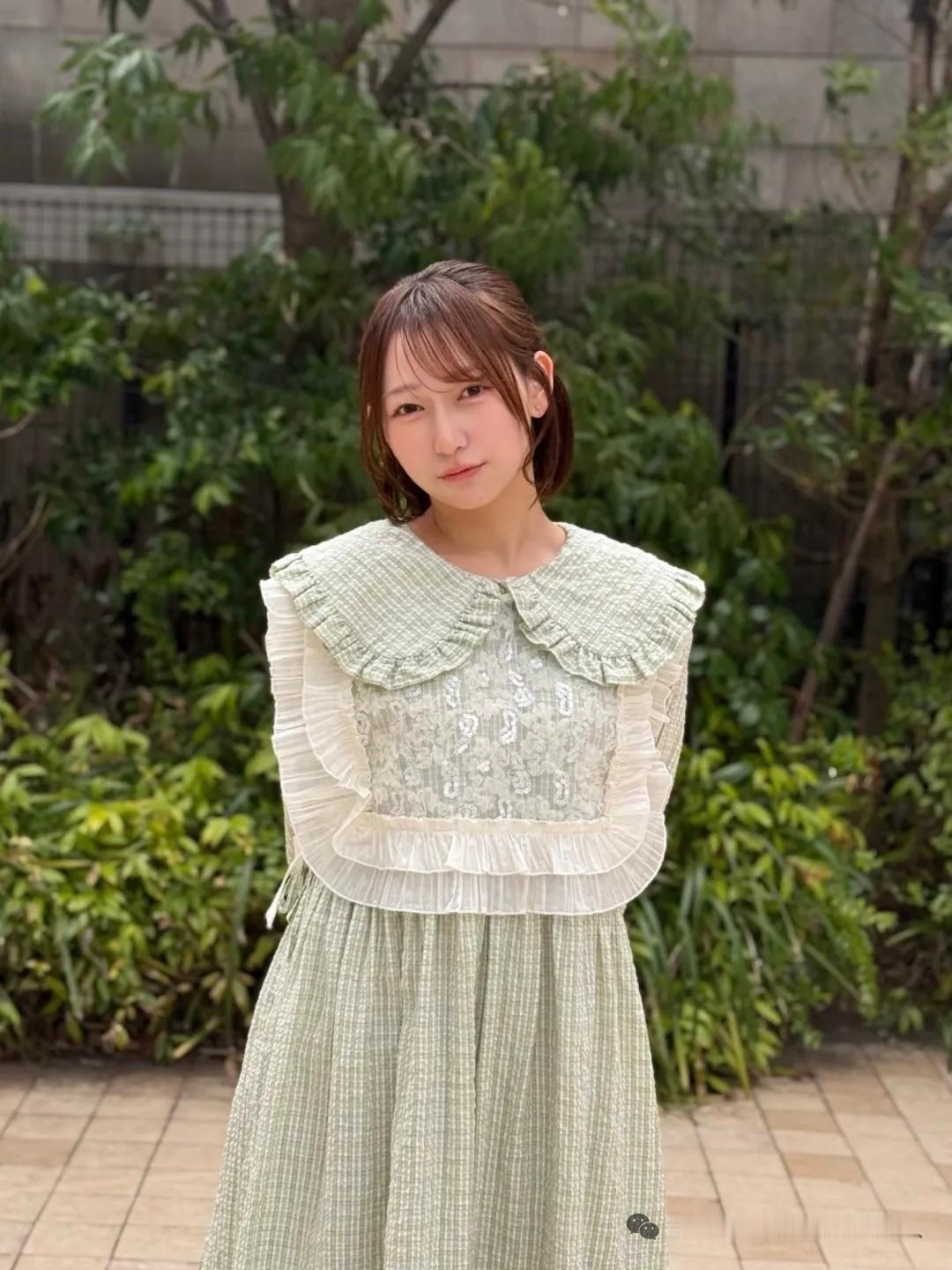 一个女孩穿着绿色连衣裙在户外。