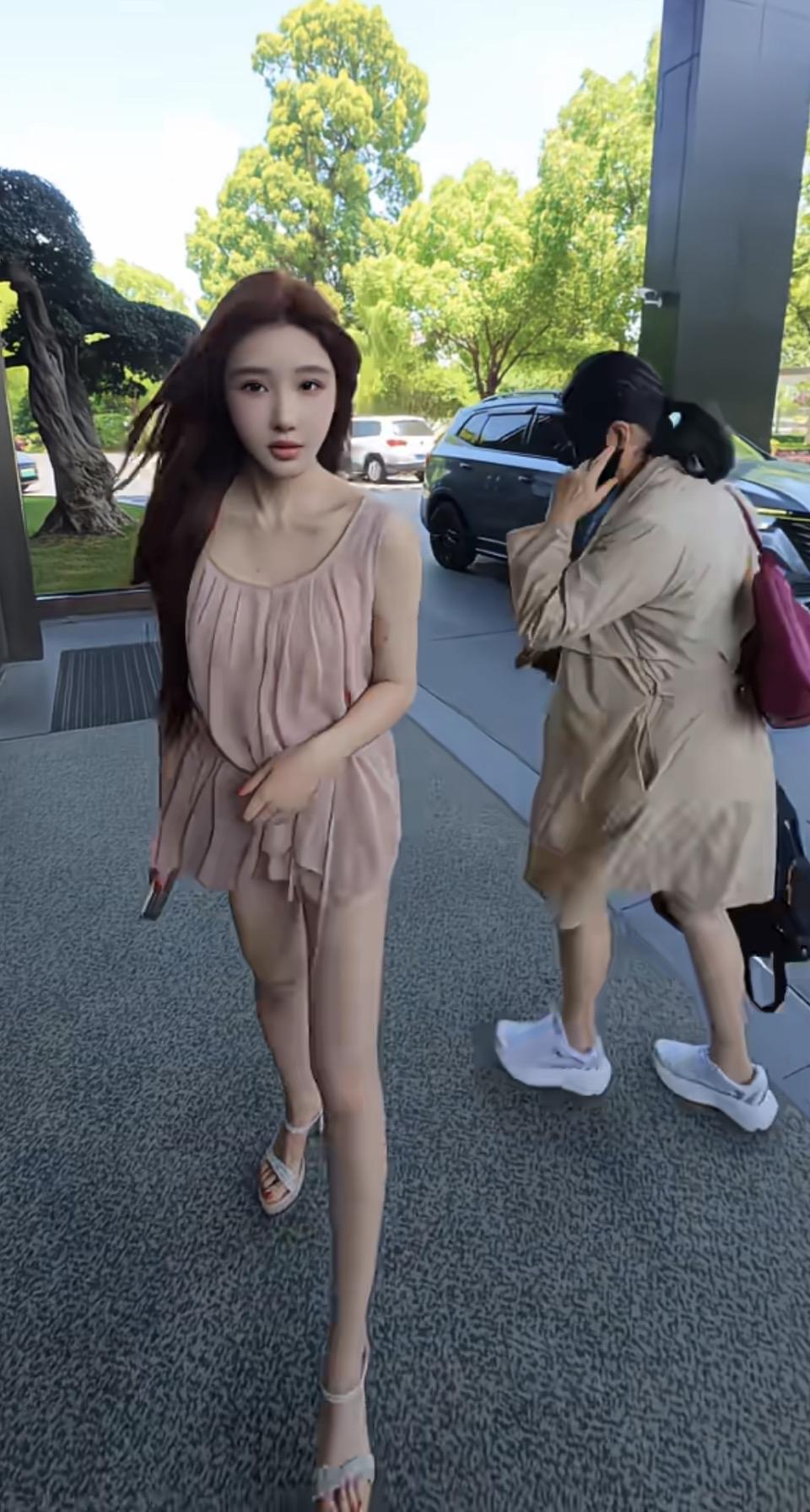 两个女生在户外走路，一个在打电话。