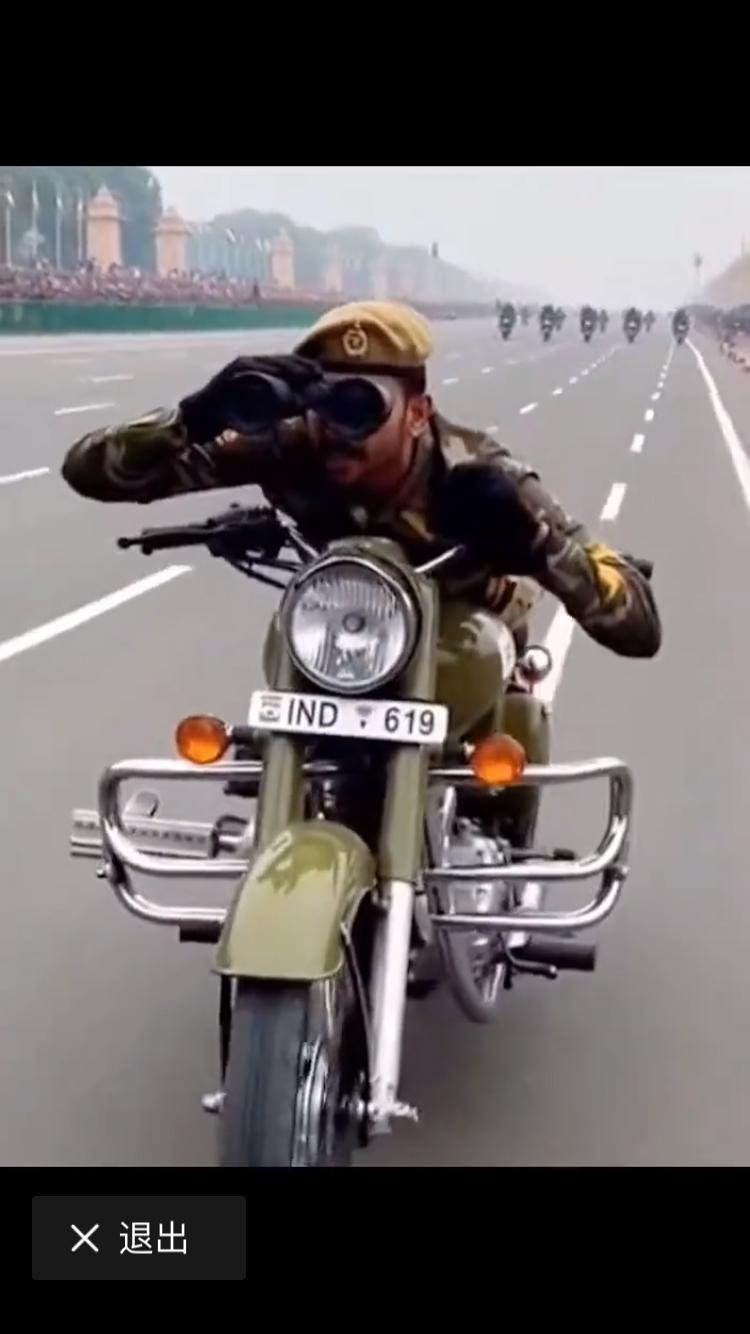 双手脱离车把，一手拿着望远镜，身形优雅飘逸。用身体的腹部与摩托车相接触，展示了高