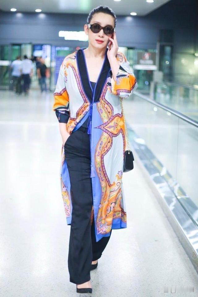 秦海璐机场造型真抢眼！穿印花开衫配喇叭裤，完全没有大妈味！ 