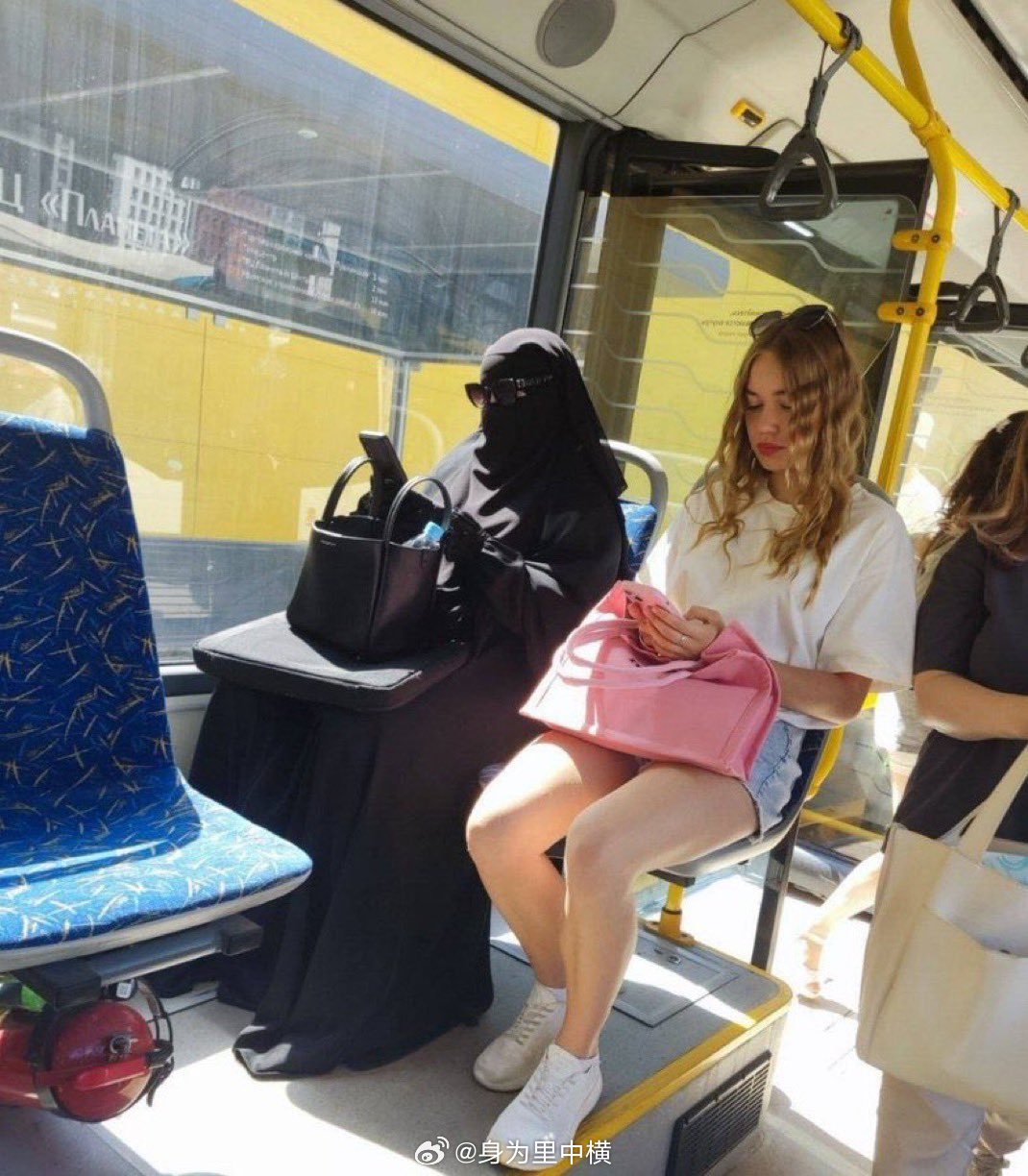 两名女性在同一辆公共汽车上挨着坐在一起，却相隔1400年。 