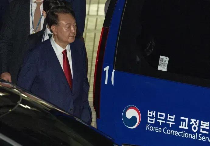 在特检组的强大压力审问下，尹锡悦终于低头认罪了，他被押上了警车，看上去非常地低沉