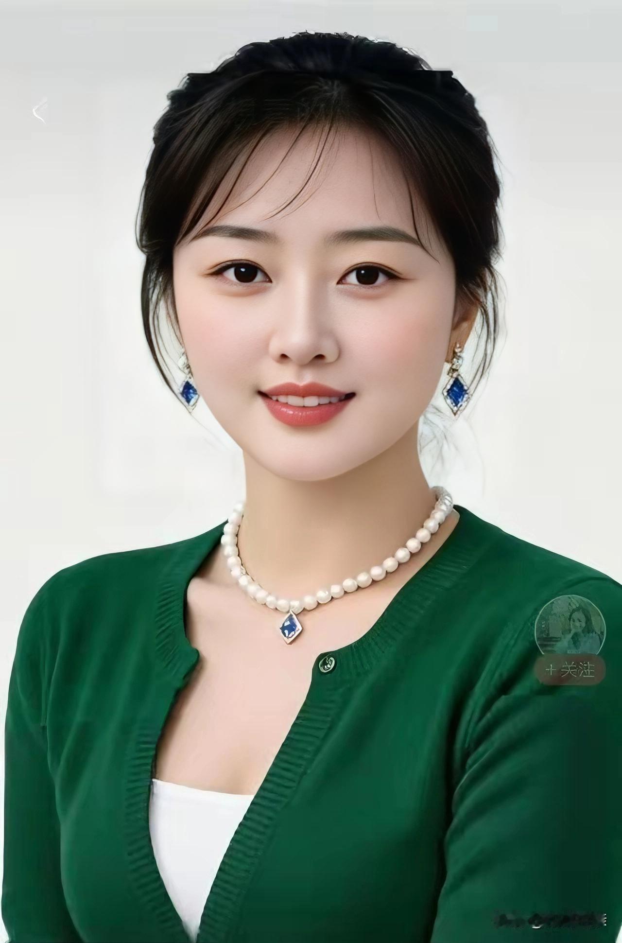 温婉丽人
一头青丝梳理匀，
耳悬蓝宝色纯真。
珍珠项链添神韵，
绿衫素朴且端庄。