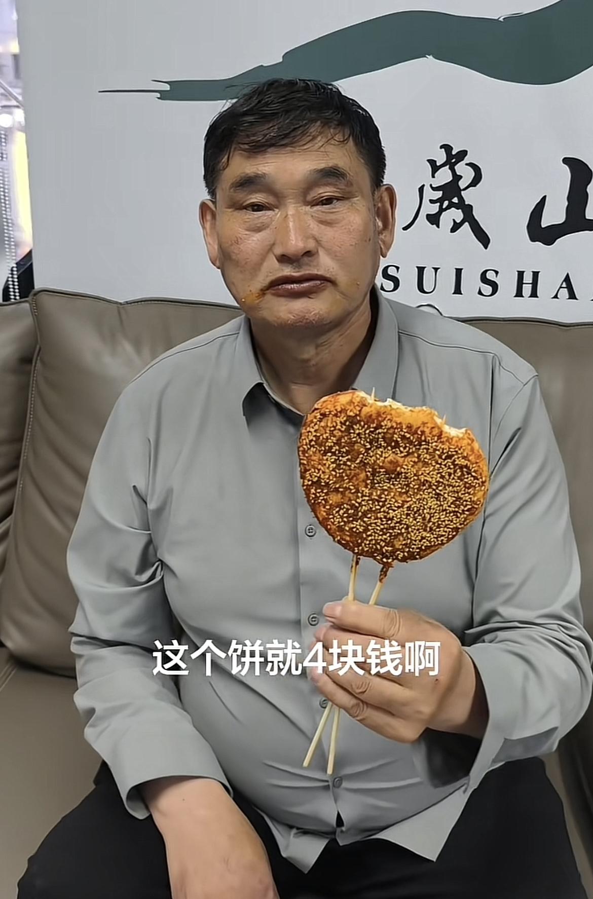“这么好吃的饼贵不贵啊？”万岁山景区，大衣哥手里擎着一个饼，一边吃一边跟工作人员