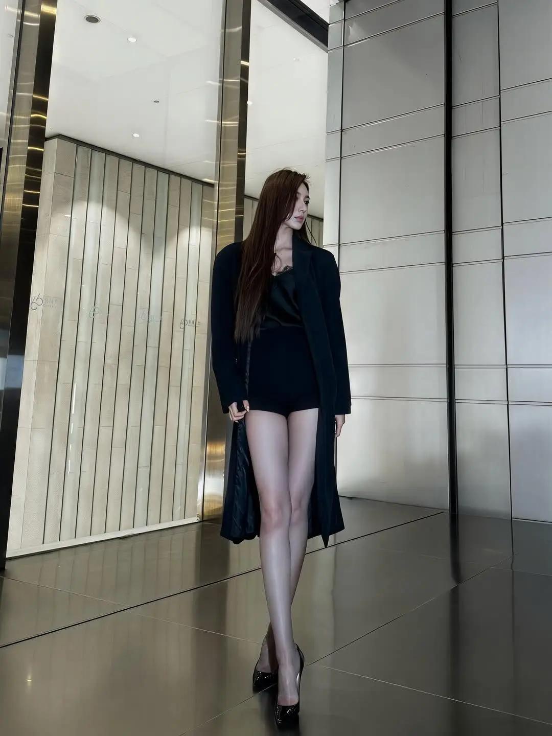 这位女士穿着黑色套装，气场十足，大长腿格外吸睛。