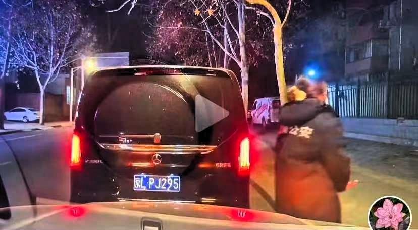 某街道，两个女车主因为冲突在路边等待交警的到来。奔驰女车主从后备箱拿出一件公安大