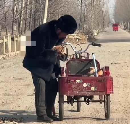 1月14日，山东临沂，一老人从三轮车里拿出烧费的蜂窝煤丢在路上，然后老人一点点将