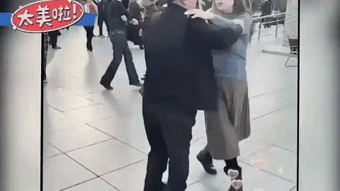 市内一处休闲广场，见到一位穿着深色衣服的大爷，找到了熟悉的大妈，两人跳起来优美的