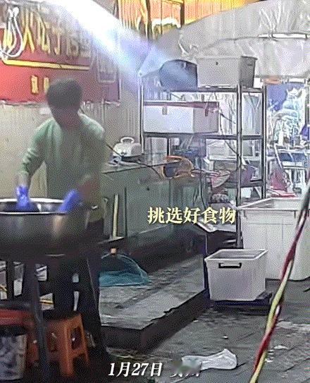 贵州，一烤鱼店老板在摊位前整理食材时，看到旁边有只流浪猫，老板见小猫可怜，便从盆