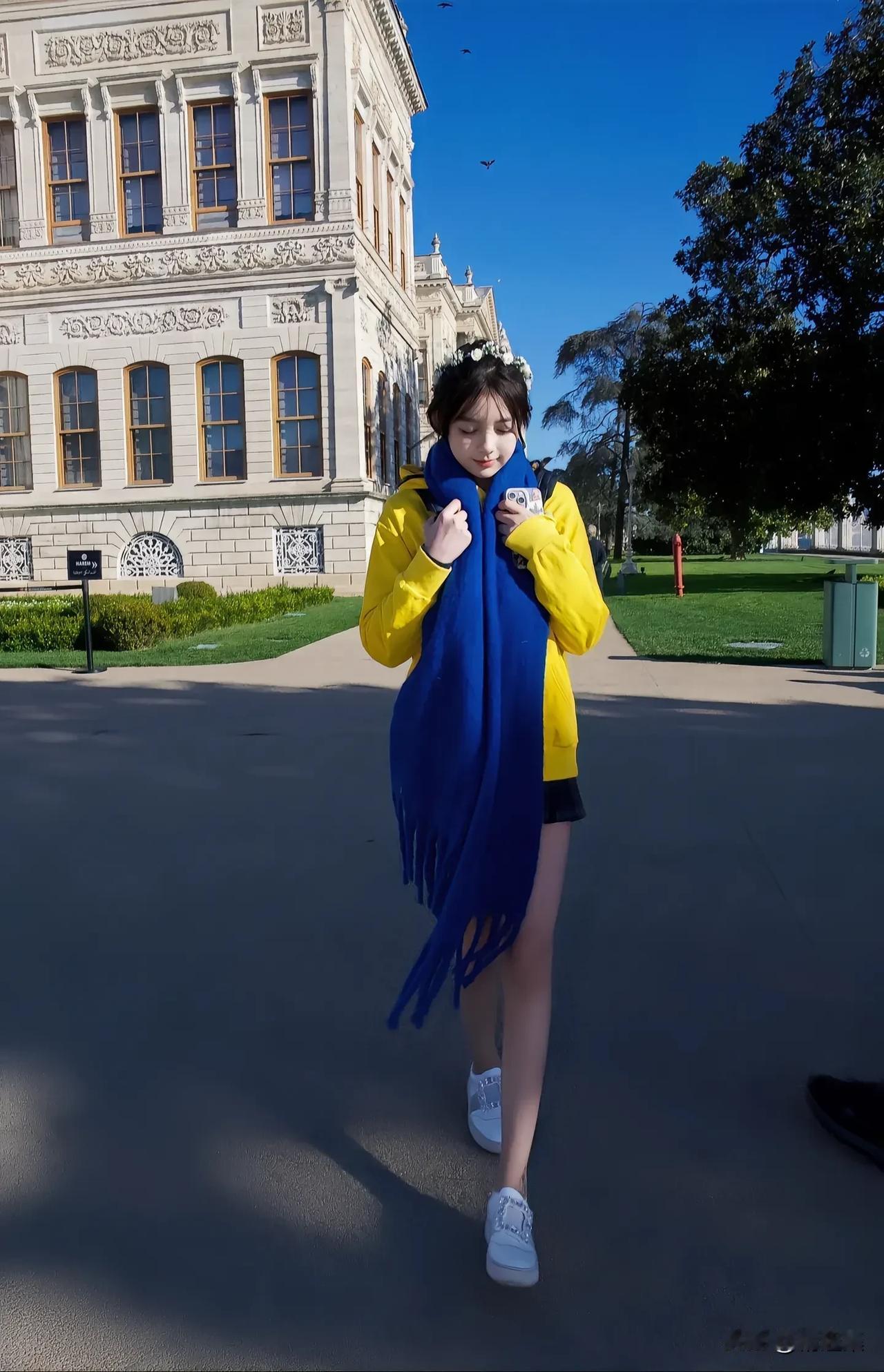 阳光明媚的日子，蓝黄相间的围巾，漫步在校园的美丽建筑前。