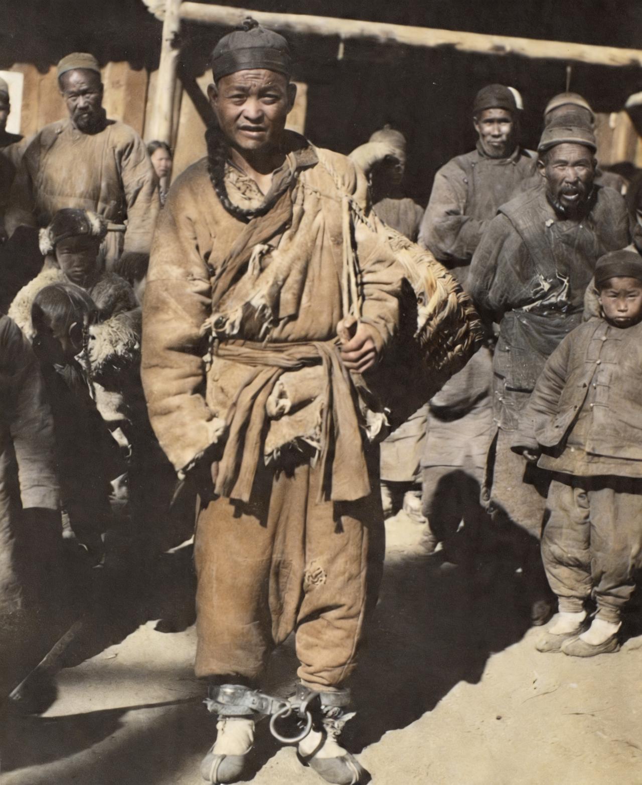 这是晚清一名男子脚上戴着脚镣背着一个筐子像日常中一样生活。清朝的刑罚正式规定为笞