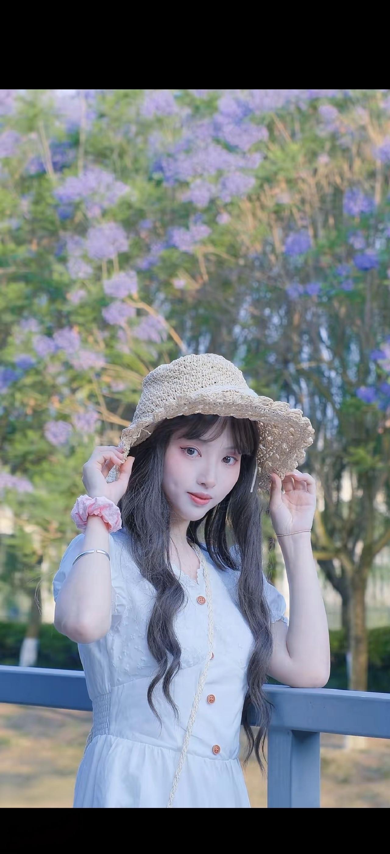 阳光明媚的午后，少女在花丛中轻抚草帽，尽显清新与甜美。