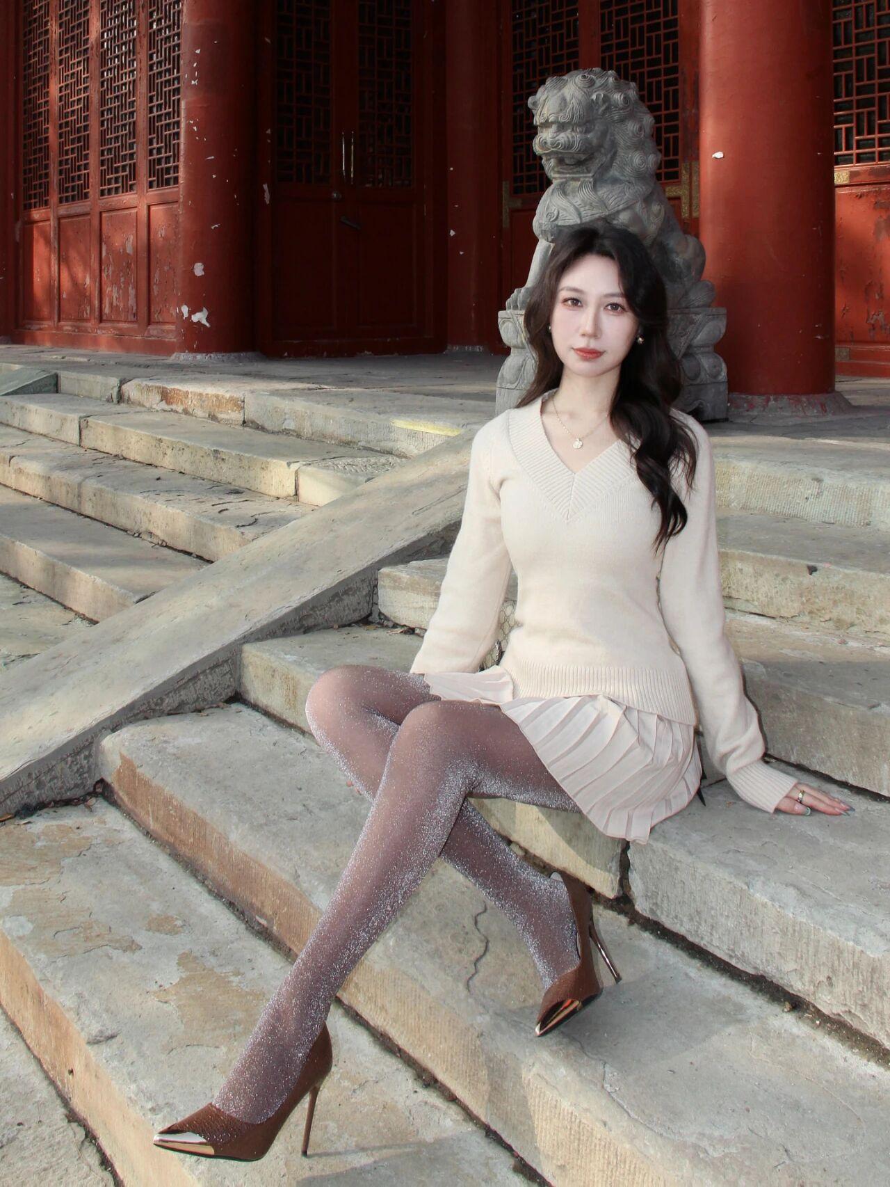 阳光斜斜地洒在青石阶上，一位女子静静地坐着，如同从时光深处走来的画中人。她的浅色