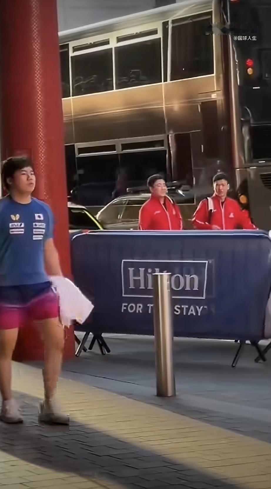 王楚钦走过来了！
视频中，夕阳下的伦敦世乒赛训练场馆外边，先是大胖梁靖崑和向鹏两