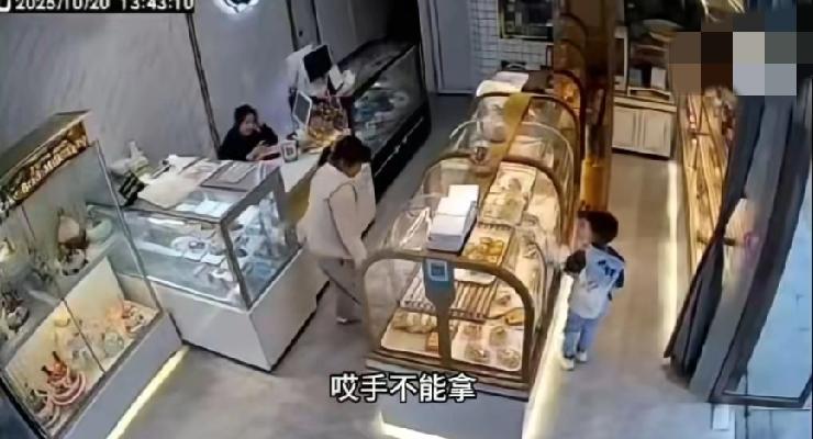 江西景德镇。一蛋糕店里面，孩子想用手去拿蛋糕，被店员好心提醒不要用手摸，孩子妈妈