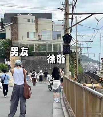徐璐 吴崇轩日本镰仓的街道上，海风轻拂过木质栏杆，徐璐穿着浅蓝连衣裙，站在江之岛