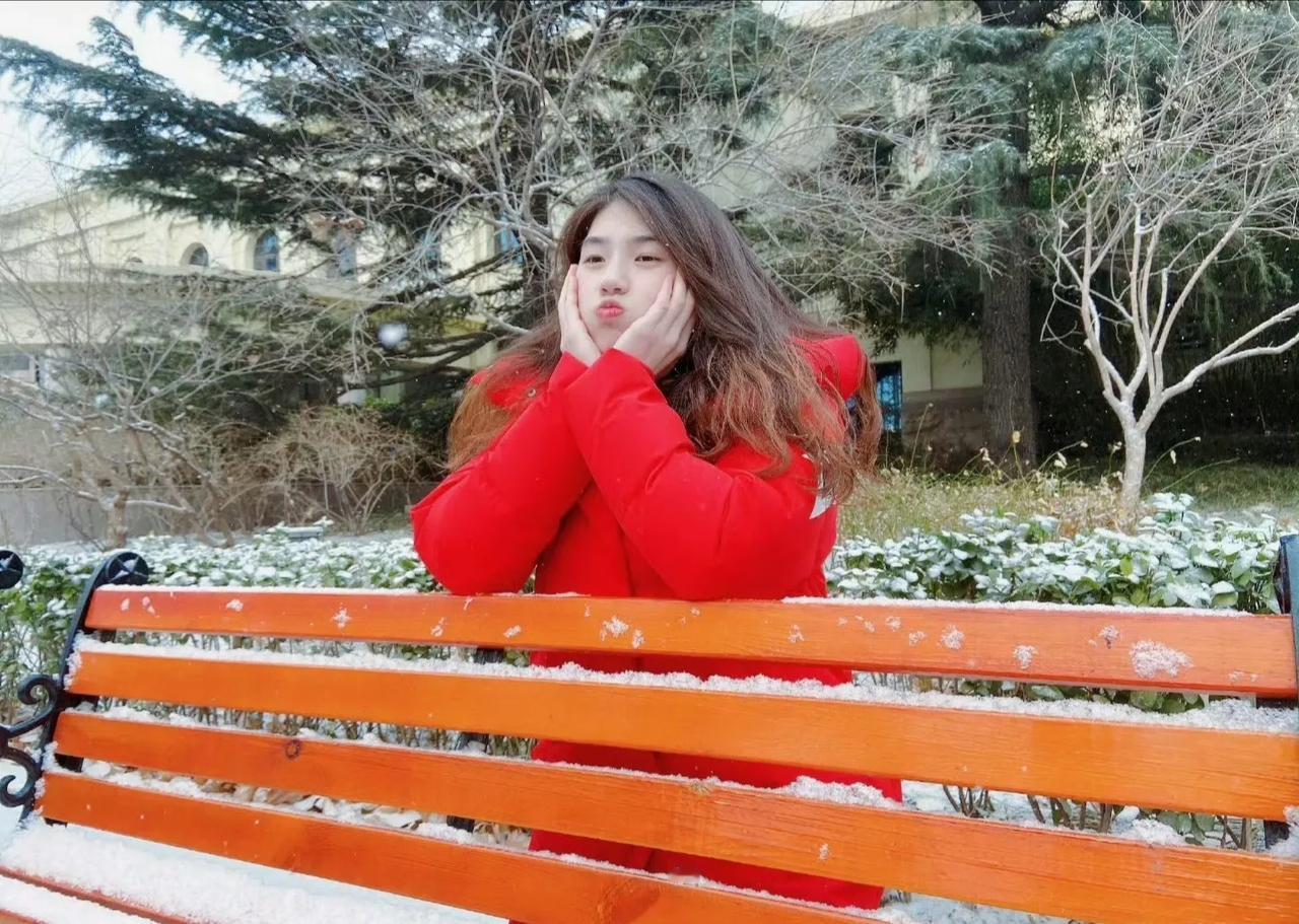 白色的冰雪世界里，她就犹如雪中的精灵一样。纯洁而可爱。手捧着脸庞，嘟起的小嘴。微